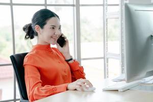 una joven gerente empresaria asiática haciendo llamadas foto