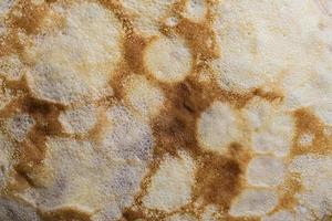 Pancake surface texture and pattern. Close-up of thin hot pancakes in a plate. Traditional rustic food. Graphic resource. photo