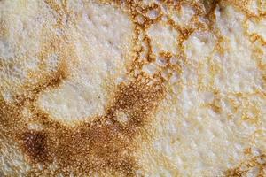 Pancake surface texture and pattern. Close-up of thin hot pancakes in a plate. Traditional rustic food. Graphic resource. photo