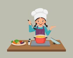 cute little girl chef cooking delicious vegetable soup with hand showing for copy space