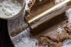 gingerbread dough on round marble with gold rolling pin top view photo