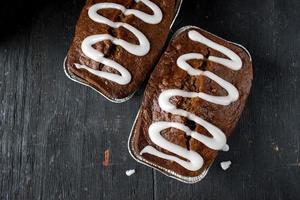 pumpkin pecan bread loaf with sugar glaze drizzle on dark wood table photo