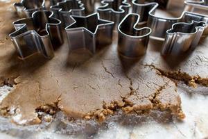 cortadores de galletas de navidad en masa de pan de jengibre foto