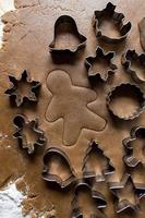 Christmas cookie cutters on gingerbread dough flat lay photo