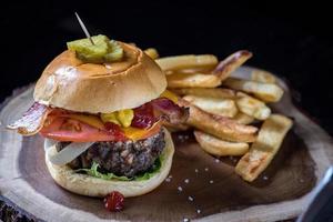 classic hamburger with tomato, lettuce, cheese, and pickles with fries photo
