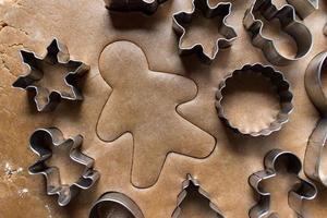 Christmas cookie cutters on gingerbread dough flat lay photo