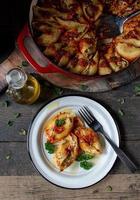 manicotti pasta shells with spinach, ricotta, mozzarella cheese in tomato sauce on plate in rustic setting flat lay photo