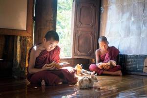 NYAUNGSHWE, MYANMAR - OCT 05 2014 - Myanmar novice reading the book in the Shwe Yaunghwe Kyaung monastery the big window temple in Myanmar. photo