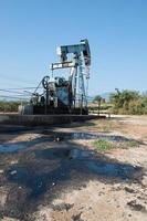 pump jack with crude oil contamination photo