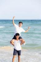 Homosexual portrait young asian couple riding the neck together with enjoy and fun on beach in summer, asia gay cheerful going sea for leisure with romantic and happy vacation at sea, LGBT with legal. photo