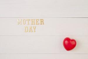 Happy mother day with symbol heart shape and text on wooden table, feeling romantic and care with decoration, word and massage present in festive with sign on desk, top view, holiday concept. photo