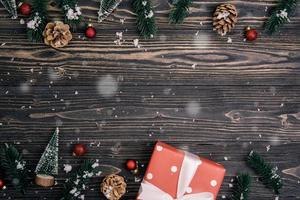 Christmas holiday composition with red gift box and tag decoration on wooden background, new year and xmas or anniversary with presents on wood table in season, top view or flat lay. photo
