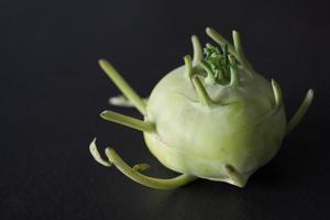 Close up of a green kohlrabi with its strange tentacles. Black background photo