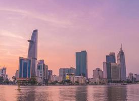 ho chi minh, vietnam - 19 de febrero de 2022 vista del edificio de la torre financiera bitexco, edificios, carreteras, puente thu thiem y río saigon en la ciudad de ho chi minh al atardecer. imagen panorámica de alta calidad. foto