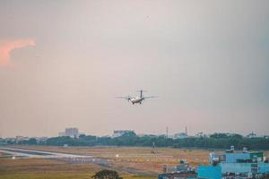 ciudad de ho chi minh, vietnam - 12 de febrero de 2022, un avión vuela sobre áreas urbanas preparando el aterrizaje en el aeropuerto internacional de tan son nhat y despega en el aeropuerto de tsn foto