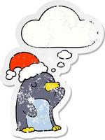 cute cartoon christmas penguin and thought bubble as a distressed worn sticker vector