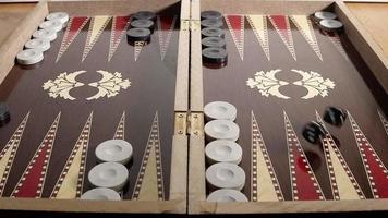 backgammon is een prachtige stockvideo die beelden toont van het traditionele Turkse backgammon-spelbord. hand gooit dobbelstenen in slow motion. video