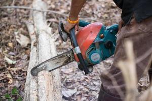 Man cutting the wood with chainsaw photo