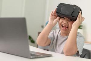 Asian Little boy with VR glasses studying sciences at home,curious student wears a virtual reality headset to study science home online study futuristic lifestyle learning photo