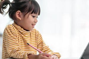 Kid self isolation using tablet for his homework,Child doing using digital tablet searching information on internet during covid 19 lock down,Home schooling,Social Distance,E-learning online education photo