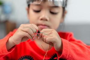 Asia students learn at home in coding robot cars and electronic board cables in STEM, STEAM, mathematics engineering science technology computer code in robotics for kids concept. photo