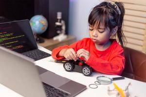 Asia students learn at home in coding robot cars and electronic board cables in STEM, STEAM, mathematics engineering science technology computer code in robotics for kids concept. photo