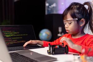 los estudiantes de asia aprenden en casa a codificar autos robot y cables de tableros electrónicos en tallo, vapor, ingeniería matemática, ciencia, tecnología, código de computadora en robótica para el concepto de niños. foto