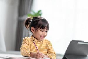 Kid self isolation using tablet for his homework,Child doing using digital tablet searching information on internet during covid 19 lock down,Home schooling,Social Distance,E-learning online education photo