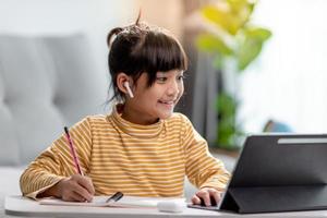 Kid self isolation using tablet for his homework,Child doing using digital tablet searching information on internet during covid 19 lock down,Home schooling,Social Distance,E-learning online education photo