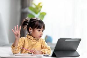 Kid self isolation using tablet for his homework,Child doing using digital tablet searching information on internet during covid 19 lock down,Home schooling,Social Distance,E-learning online education photo