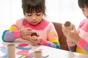 Little cute girl with painted tissue core. Art makes children learn and create. photo