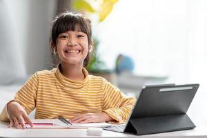 Kid self isolation using tablet for his homework,Child doing using digital tablet searching information on internet during covid 19 lock down,Home schooling,Social Distance,E-learning online education photo