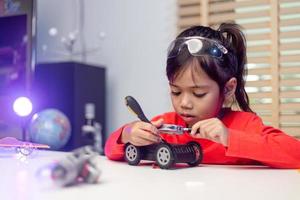 Asia students learn at home in coding robot cars and electronic board cables in STEM, STEAM, mathematics engineering science technology computer code in robotics for kids concept. photo