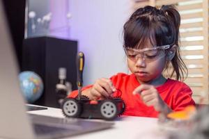 Asia students learn at home in coding robot cars and electronic board cables in STEM, STEAM, mathematics engineering science technology computer code in robotics for kids concept. photo