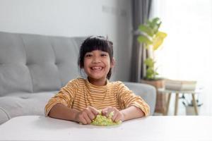 Kid play with handgum. Slime in children hands. photo