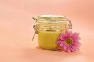 Sugar paste for depilation. Shugaring. Removing hair. Cosmetics. Honey in jar with flower. photo