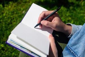 Close up of girl's hands writing and drawing in sketchbook and notepad. Education and study, time back to school. photo