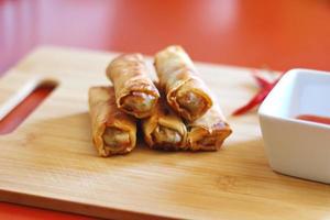 Spring rolls with chili sauce on the wooden background photo
