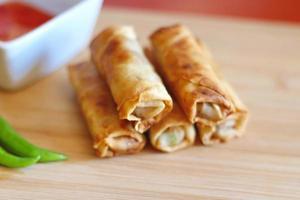 Spring rolls with chili sauce on the wooden background photo