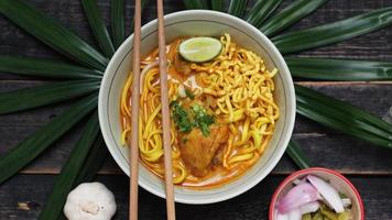 Khao Soi Recipe,Khao Soi,Khao Soi Kai, Thai Noodles Khao Soi, Chicken Curry with seasoning served on wooden table photo