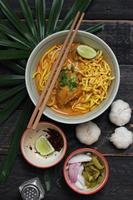 receta de khao soi, khao soi, khao soi kai, fideos tailandeses khao soi, curry de pollo con condimento servido en una mesa de madera foto