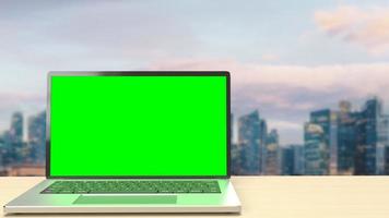 The notebook display green screen on rooftop building  for present concept 3d rendering photo