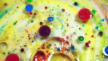 bolhas abstratas coloridas e gotas na superfície da água amarela e branca video
