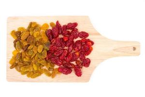 Yellow raisins and Dried Tomatoes on wooden tray. photo