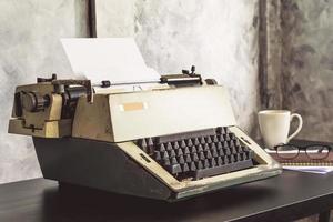 vieja máquina de escribir en el escritorio. tono antiguo foto