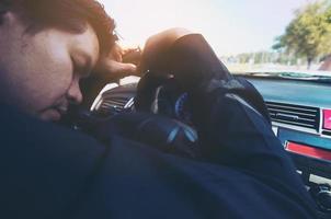 Man sleep in car while driving on the road - people tried from long drive and traffic concept photo