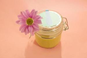 Sugar paste for depilation. Shugaring. Removing hair. Cosmetics. Honey in jar with flower. photo