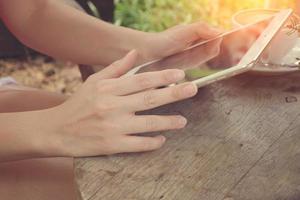 mujer que usa una tableta digital manos cerca con tono vintage foto