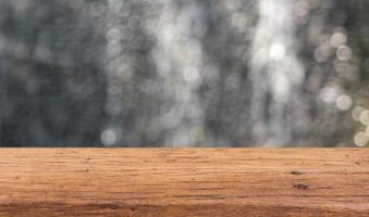 mesa de madera sobre fondo abstracto de agua borrosa para mostrar sus productos foto