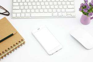 Top view of blank screen smart phone on white table work photo